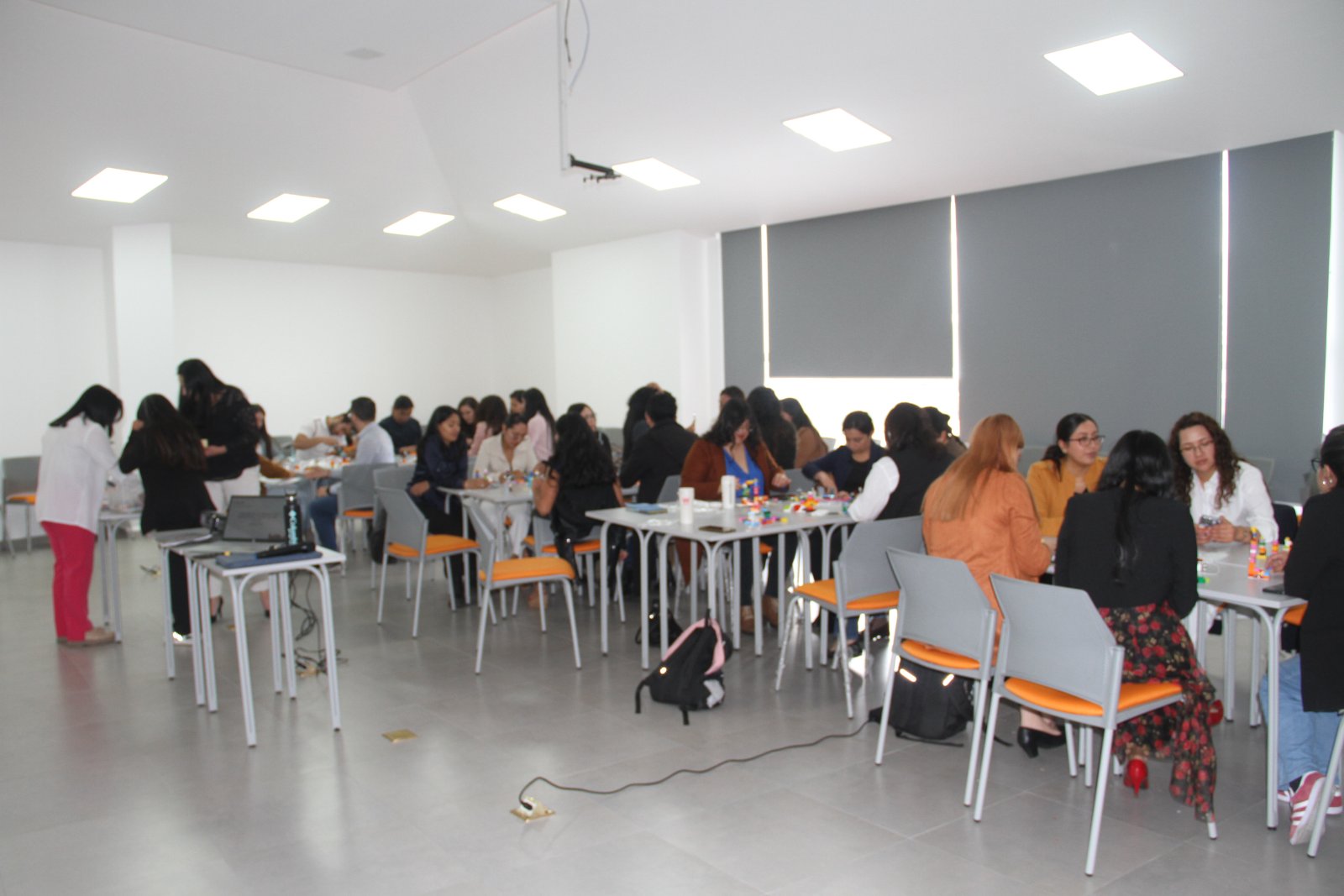 Sala llena de participantes trabajando en mesas durante el taller de marca personal de Ninari