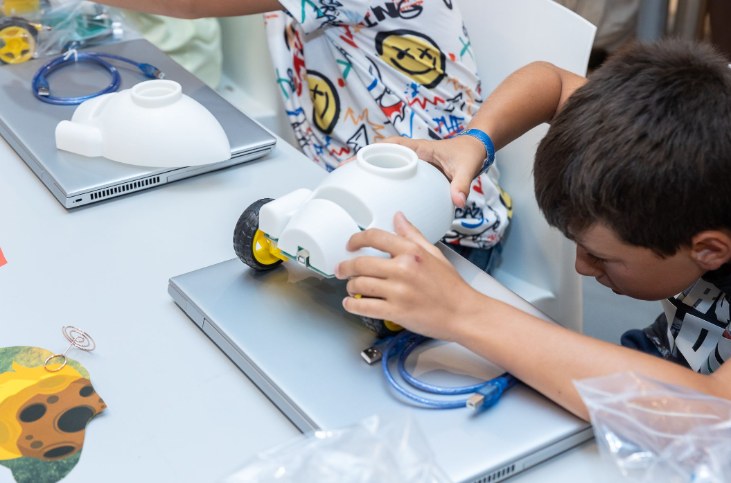 Niño arma un robot móvil en un taller STEAM de REBDI